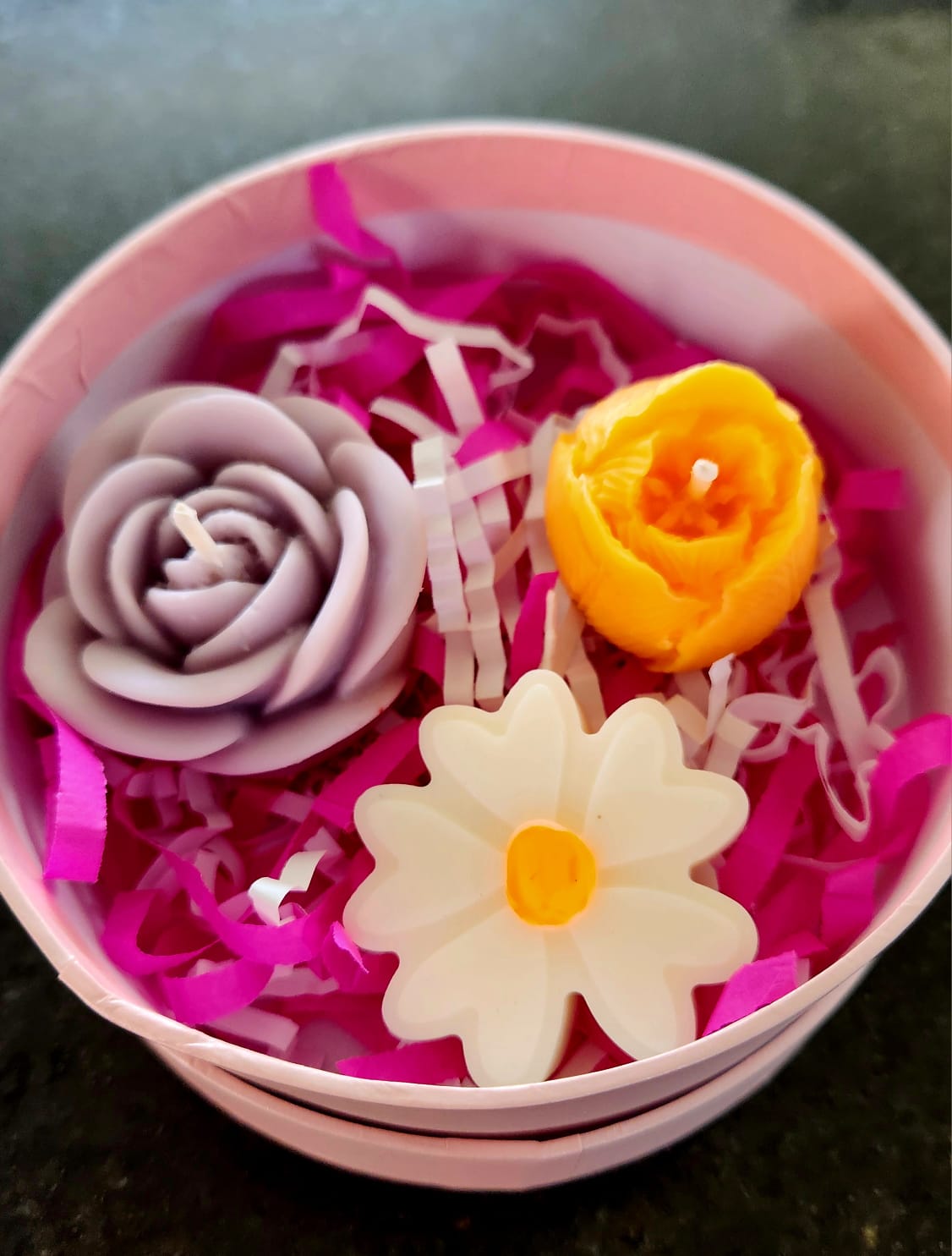 Set floral en caja circular rosa con velas lavanda naranja y margarita